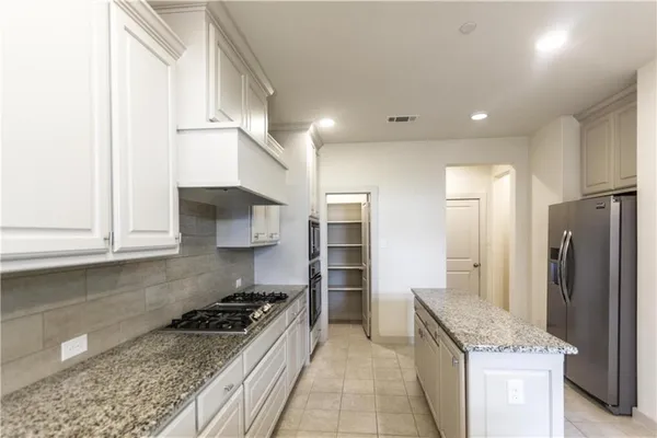 a kitchen with stainless steel appliances granite countertop a stove a refrigerator and a sink