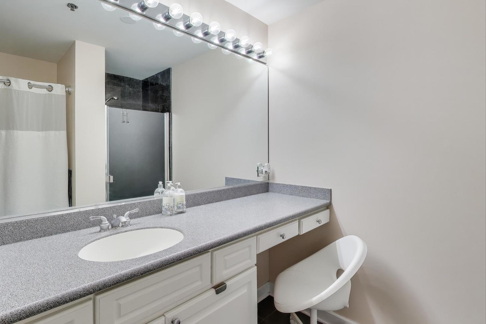1529 South State Street, Unit 14J Chicago, IL 60605 - Photo 11 of 30 a bathroom with a granite countertop sink a mirror and a toilet