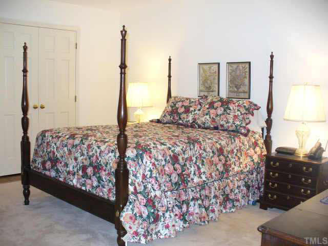 6900 Buckhead Drive Raleigh, NC 27615 - Photo 5 of 10 a bedroom with a large bed and a chandelier