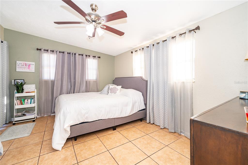 944 Halstead Street Deltona, FL 32725 - Photo 13 of 28 a bedroom with a bed and a ceiling fan