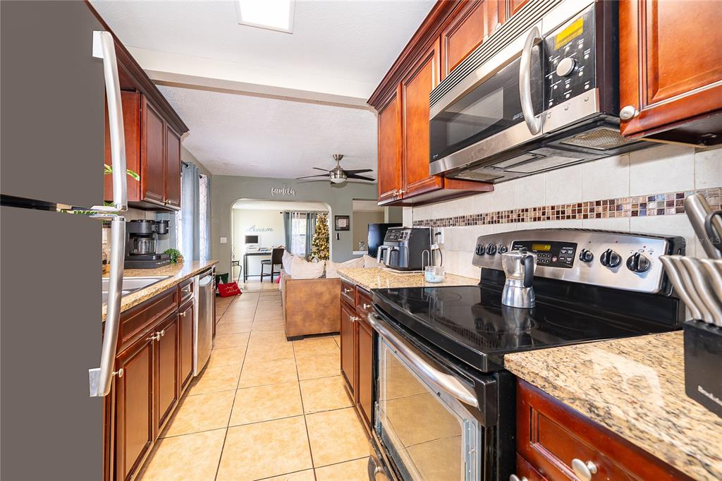 944 Halstead Street Deltona, FL 32725 - Photo 14 of 28 a kitchen with stainless steel appliances granite countertop a stove and a sink