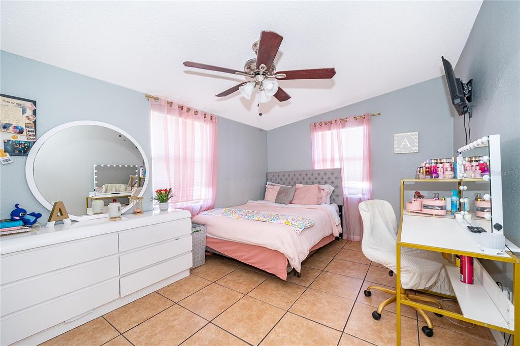 944 Halstead Street Deltona, FL 32725 - Photo 23 of 28 a bedroom with a bed and a chandelier