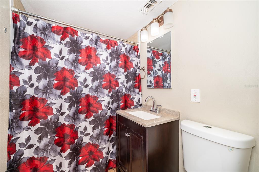 944 Halstead Street Deltona, FL 32725 - Photo 26 of 28 a bathroom with a sink and mirror with toilet