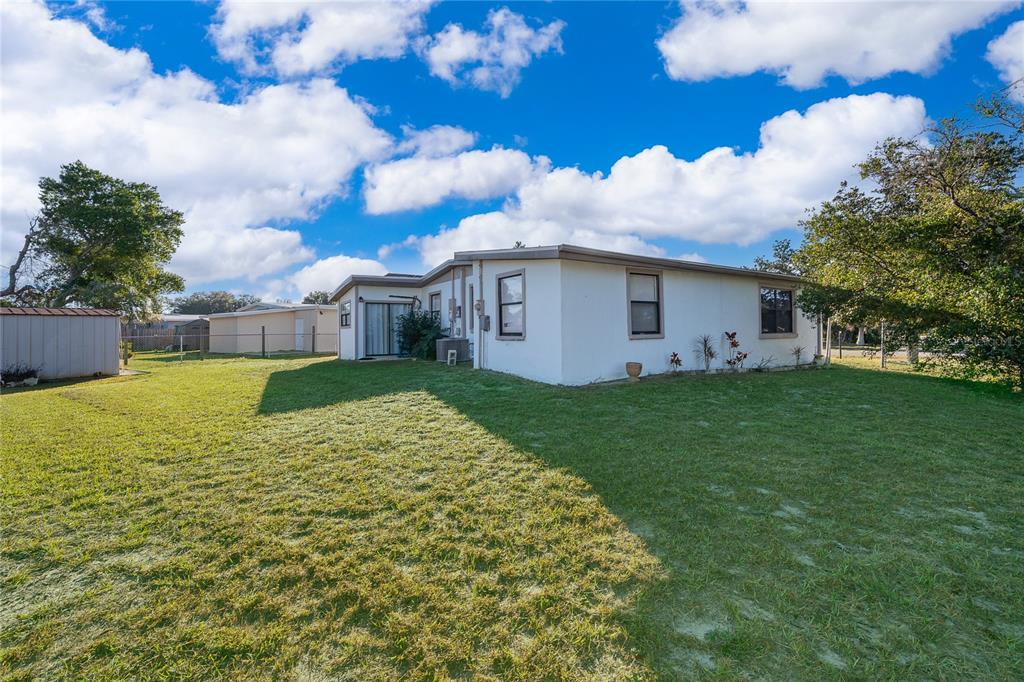 944 Halstead Street Deltona, FL 32725 - Photo 28 of 28 a view of a house with a big yard and large tree