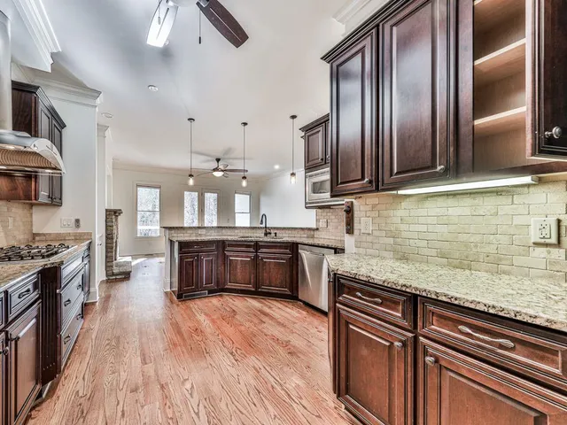 a kitchen with stainless steel appliances granite countertop a stove and a wooden cabinets