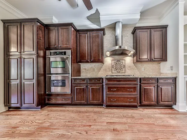 a kitchen with stainless steel appliances granite countertop a refrigerator stove and cabinets