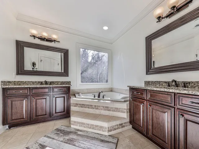 a spacious bathroom with a sink a mirror and bathtub