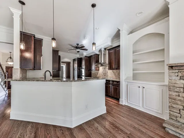a large kitchen with kitchen island a large counter top and stainless steel appliances