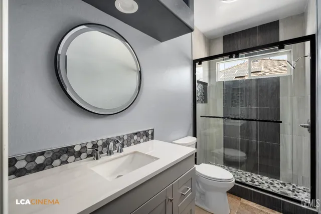 a bathroom with a sink a toilet and a mirror