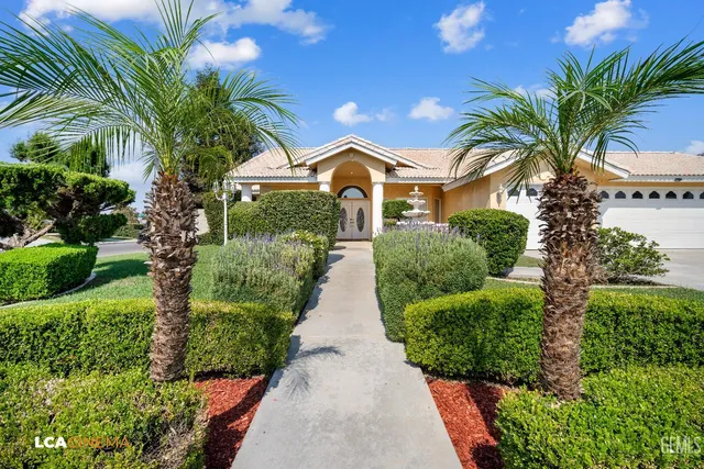 a front view of a house with a yard and potted plants