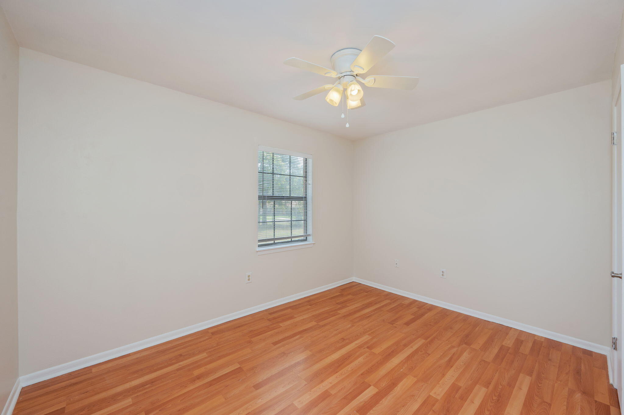 5356 Constitution Road Crestview, FL 32539 - Photo 19 of 32 an empty room with wooden floor and windows