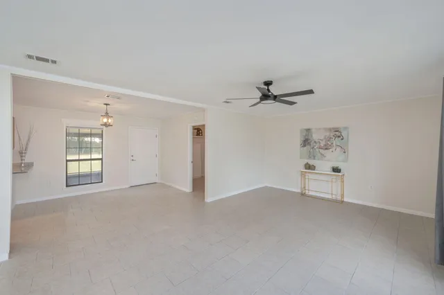 an empty room with windows and cabinet