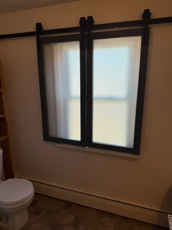 a bathroom with a toilet a sink and a window