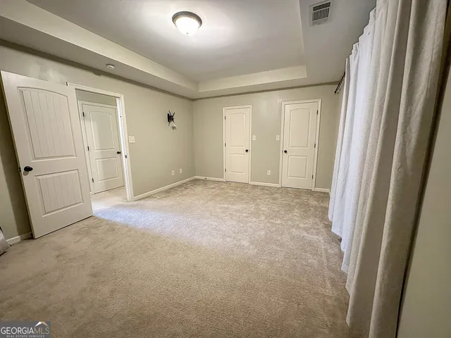 en empty room with windows and ceiling fan