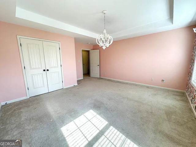 en empty room with windows and ceiling fan
