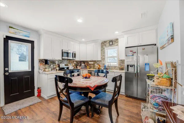 a dining area with stainless steel appliances granite countertop a dining table and chairs