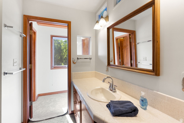 435 Canyon Road Millville, UT 84326 - Photo 33 of 113 Bathroom vanity featuring an integrated sink, polished chrome faucet, and expansive framed mirror