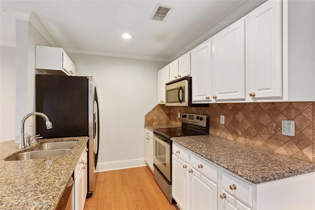 7770 Meadow Road, Unit 211 Dallas, TX 75230 - Photo 5 of 12 a kitchen with granite countertop stainless steel appliances a sink and a counter space