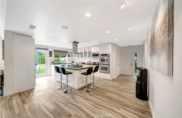 a kitchen with stainless steel appliances granite countertop a sink and a refrigerator