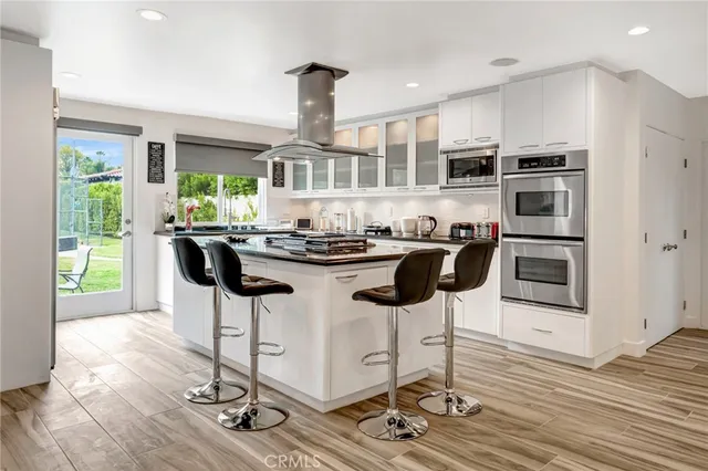 a kitchen with stainless steel appliances kitchen island granite countertop a refrigerator and cabinets