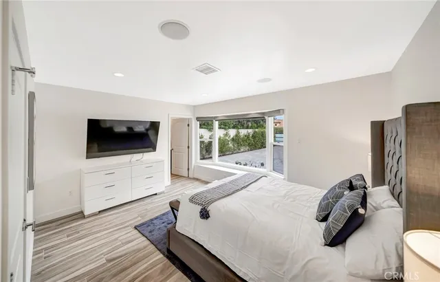 a large white bed sitting in a room next to a window