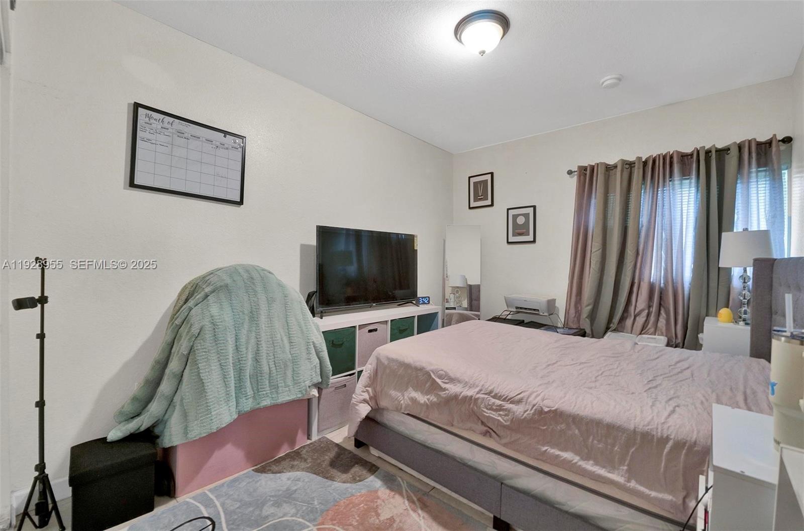 1910 Northwest 72nd Street Miami, FL 33147 - Photo 17 of 37 a bedroom with a bed and a flat screen tv