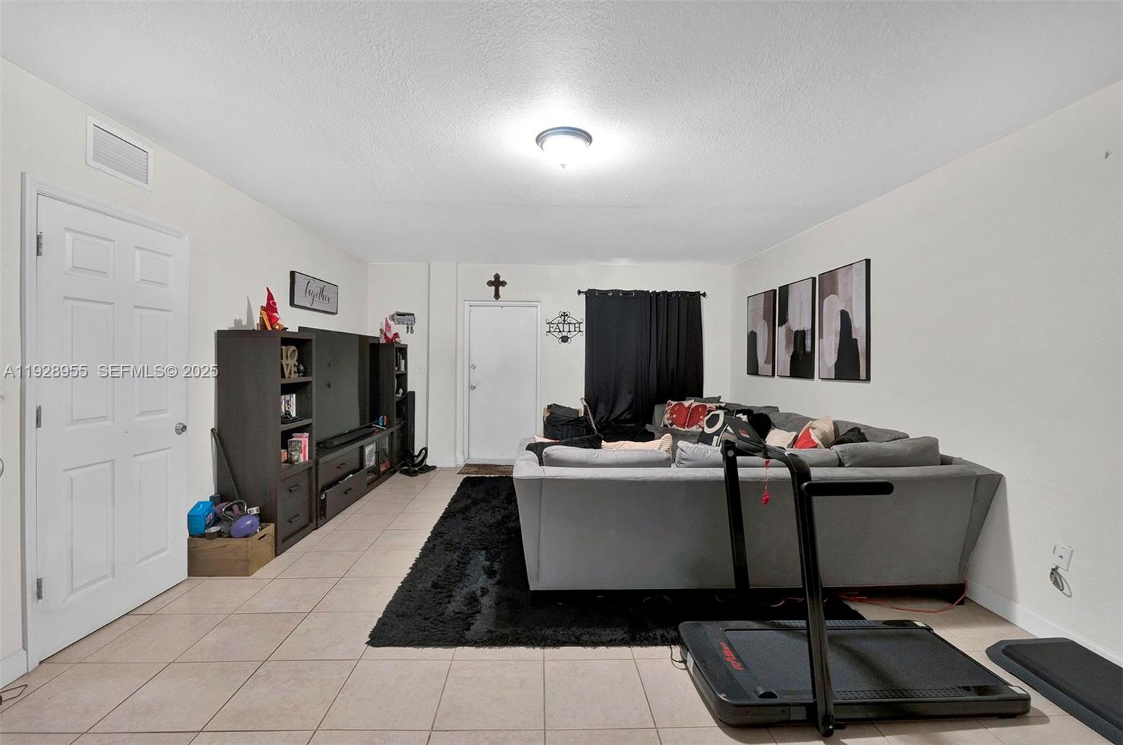 1910 Northwest 72nd Street Miami, FL 33147 - Photo 20 of 37 a living room with furniture and a flat screen tv