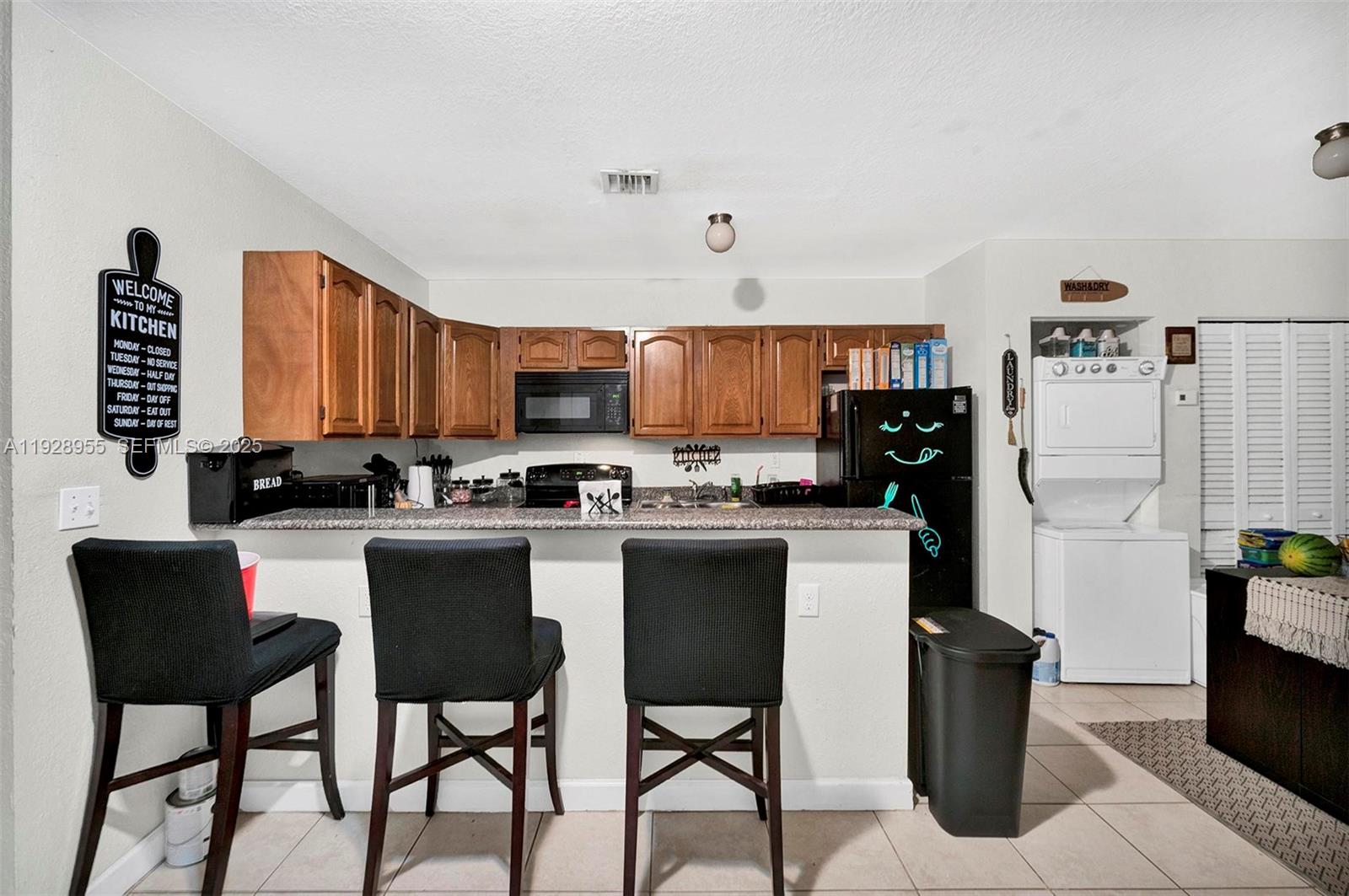 1910 Northwest 72nd Street Miami, FL 33147 - Photo 7 of 37 a kitchen with a table chairs and a refrigerator
