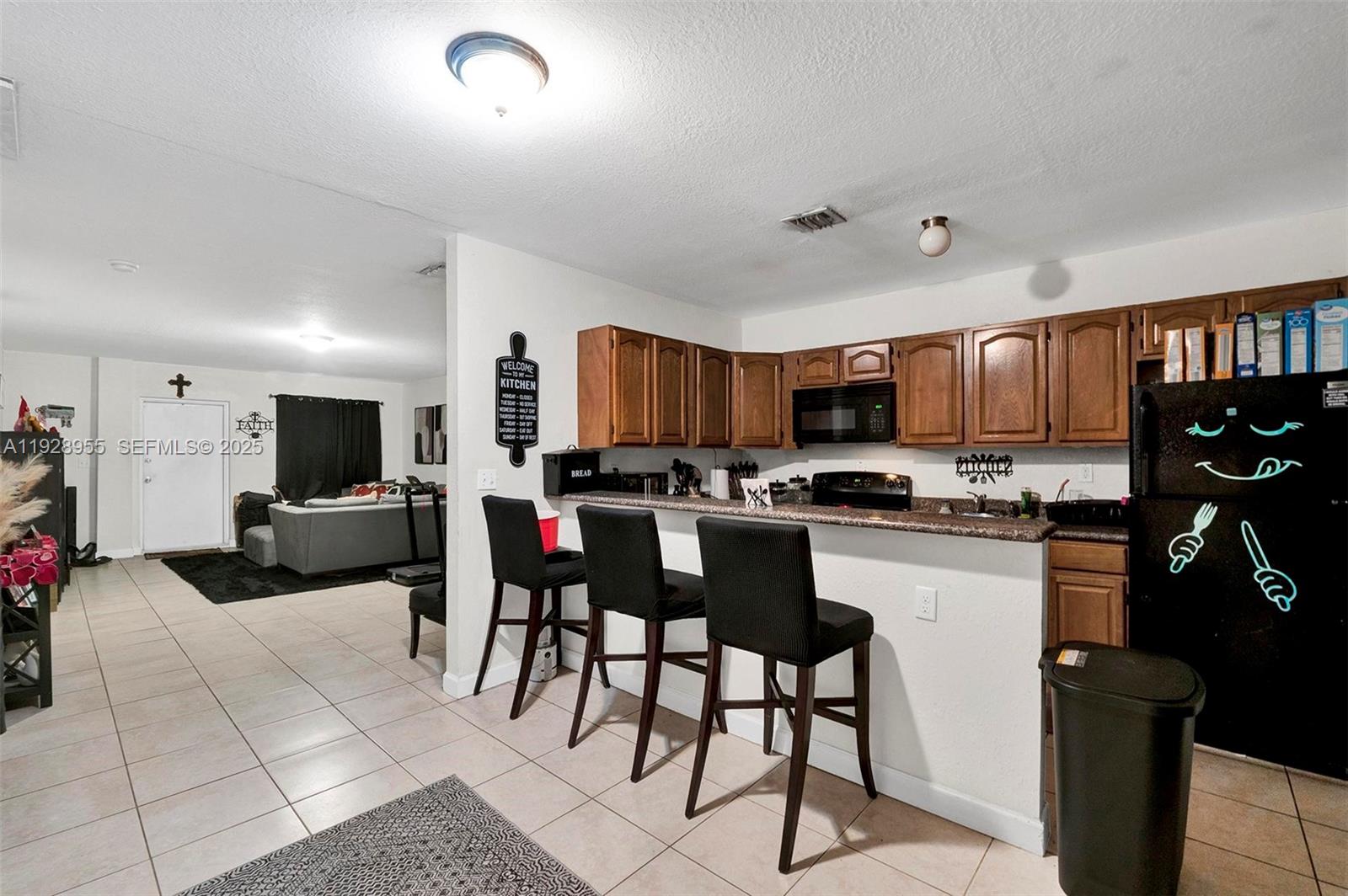 1910 Northwest 72nd Street Miami, FL 33147 - Photo 9 of 37 a living room with stainless steel appliances kitchen island granite countertop furniture and a kitchen view