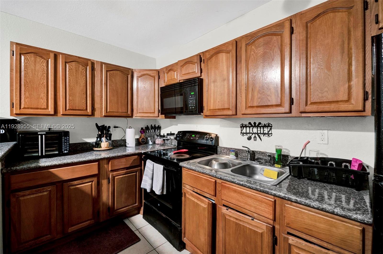 1910 Northwest 72nd Street Miami, FL 33147 - Photo 10 of 37 a kitchen with granite countertop stainless steel appliances a sink a stove top oven and cabinets