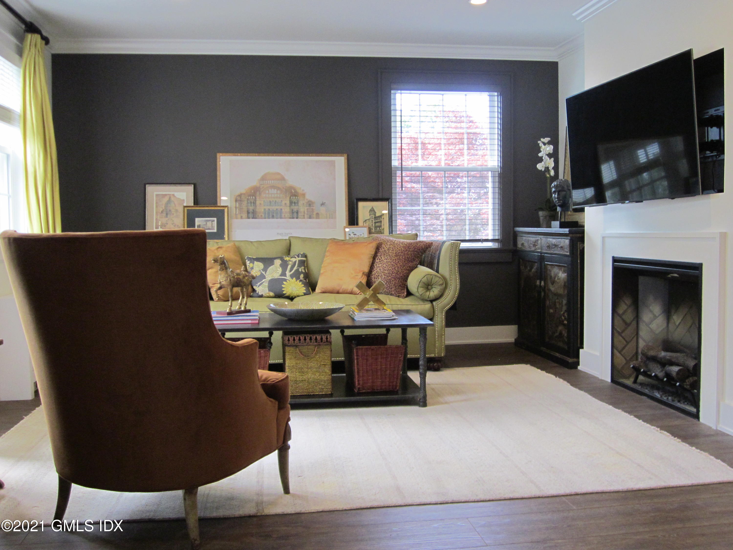 4 Putnam Park, Unit 4 Greenwich, CT 06830 - Photo 19 of 37 a living room with furniture a flat screen tv and a fireplace