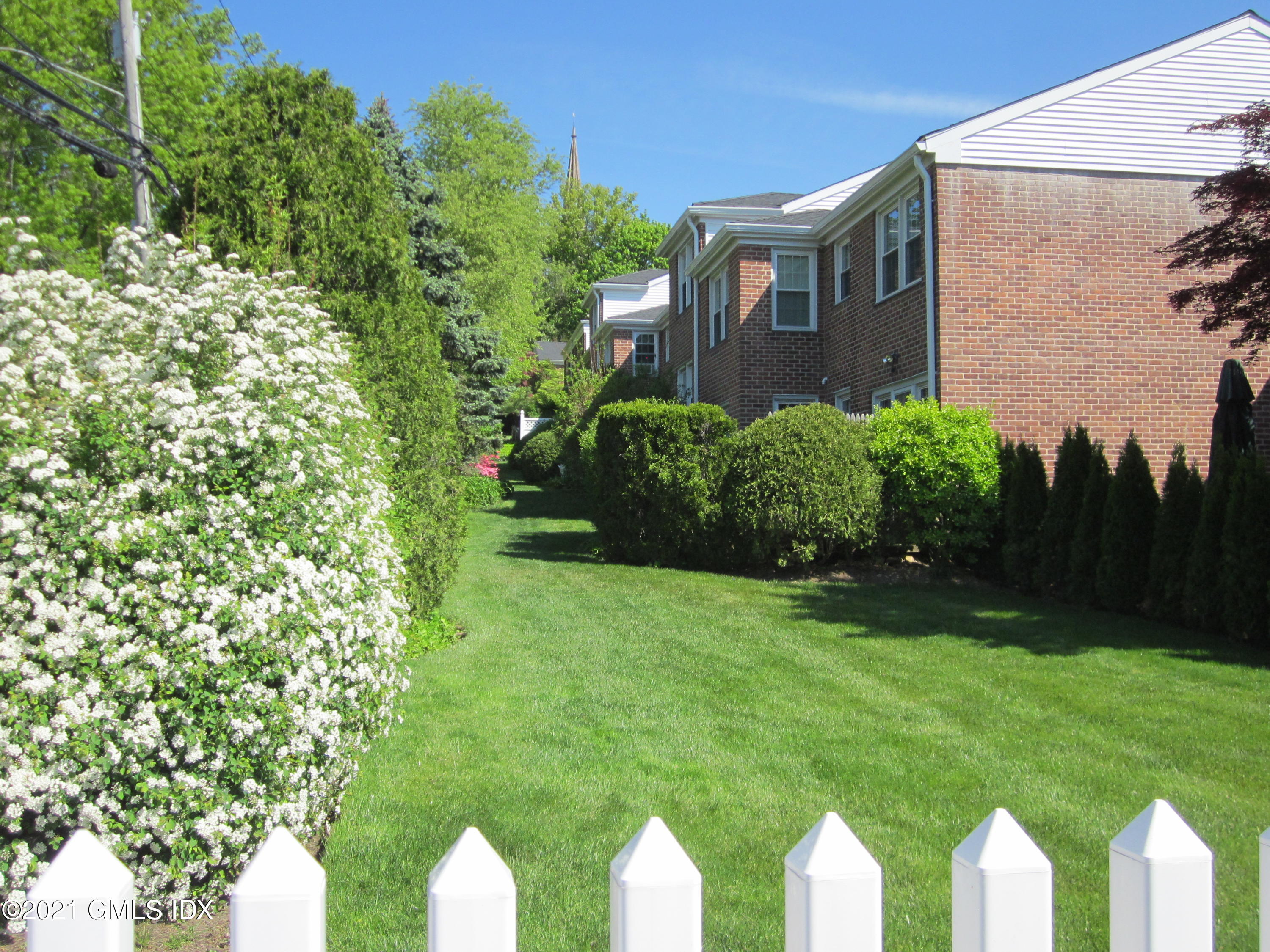 4 Putnam Park, Unit 4 Greenwich, CT 06830 - Photo 25 of 37 a front view of a house with a yard