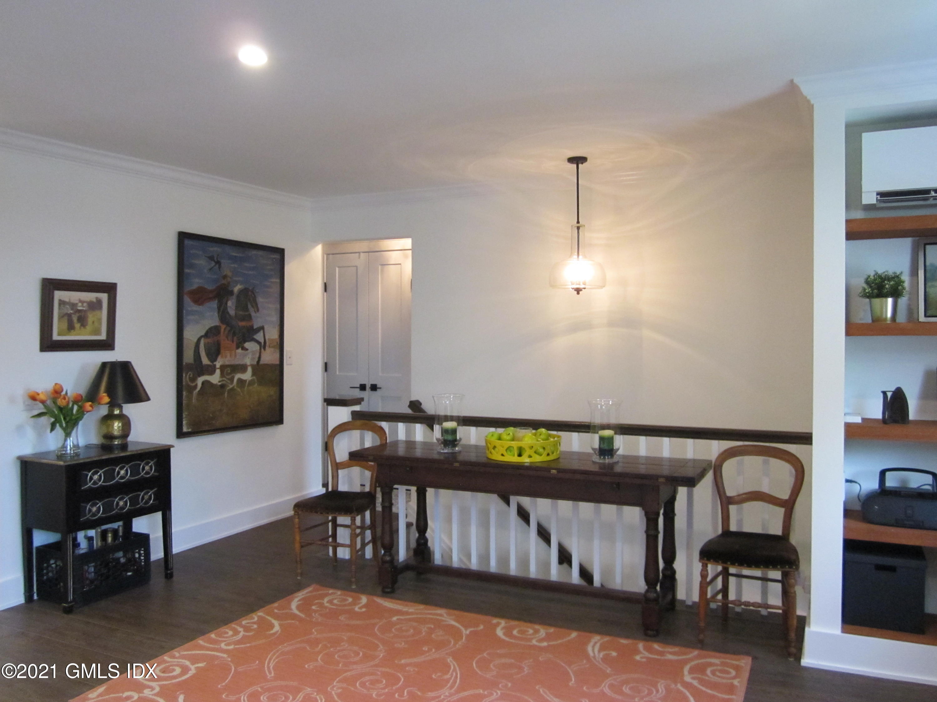 4 Putnam Park, Unit 4 Greenwich, CT 06830 - Photo 7 of 37 a living room with furniture a rug and paintings on the wall