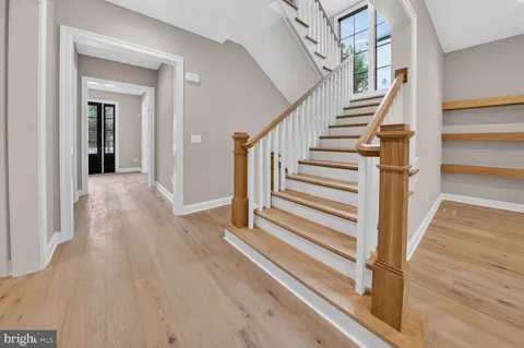 a view of a bathroom from a hallway with wooden floor