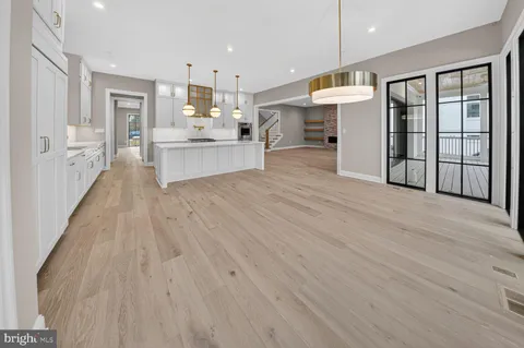 a view of a big room with wooden floor and windows