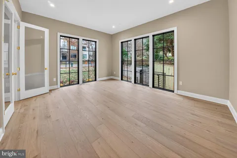 a view of an empty room with window and stairs