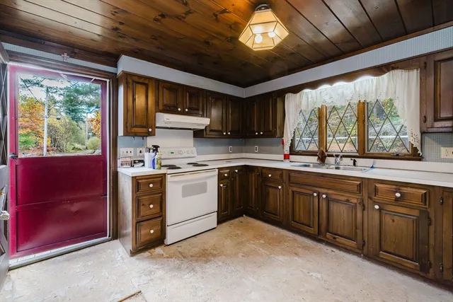 a kitchen with a refrigerator a sink and dishwasher with a dining table