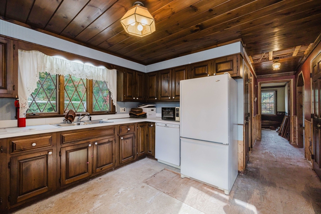 150 Quanapoag Road Freetown, MA 02717 - Photo 30 of 42 a kitchen with a refrigerator a sink and dishwasher with a dining table