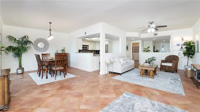 a living room with furniture a chandelier and a potted plant