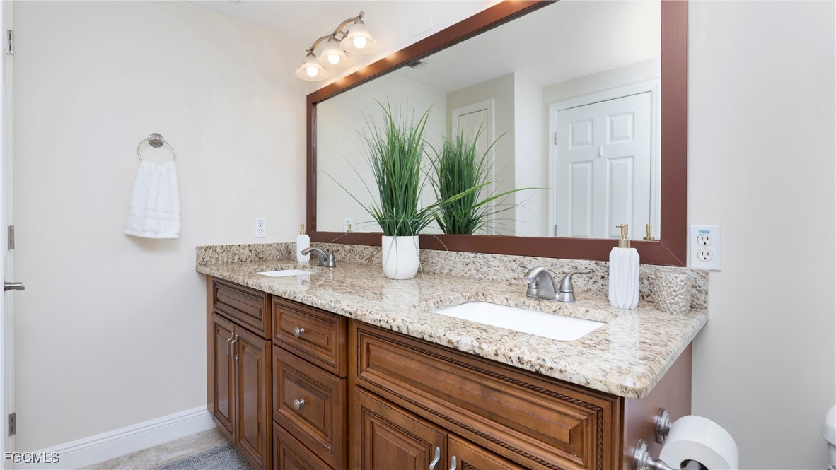 1920 Virginia Avenue, Unit 202 Fort Myers, FL 33901 - Photo 15 of 38 a bathroom with a granite countertop sink and a mirror
