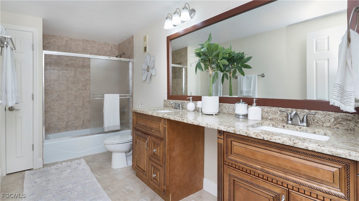 1920 Virginia Avenue, Unit 202 Fort Myers, FL 33901 - Photo 19 of 38 a bathroom with a granite countertop sink a toilet a mirror and shower