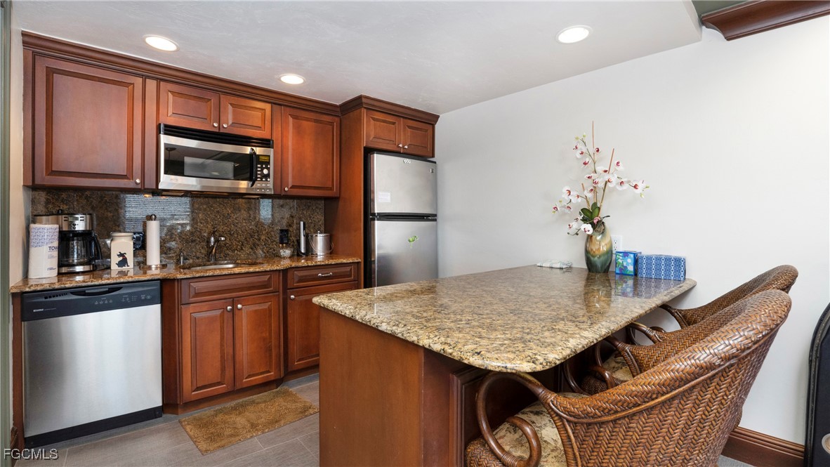 1920 Virginia Avenue, Unit 202 Fort Myers, FL 33901 - Photo 28 of 38 a kitchen with stainless steel appliances granite countertop a refrigerator a stove top oven a sink and dishwasher