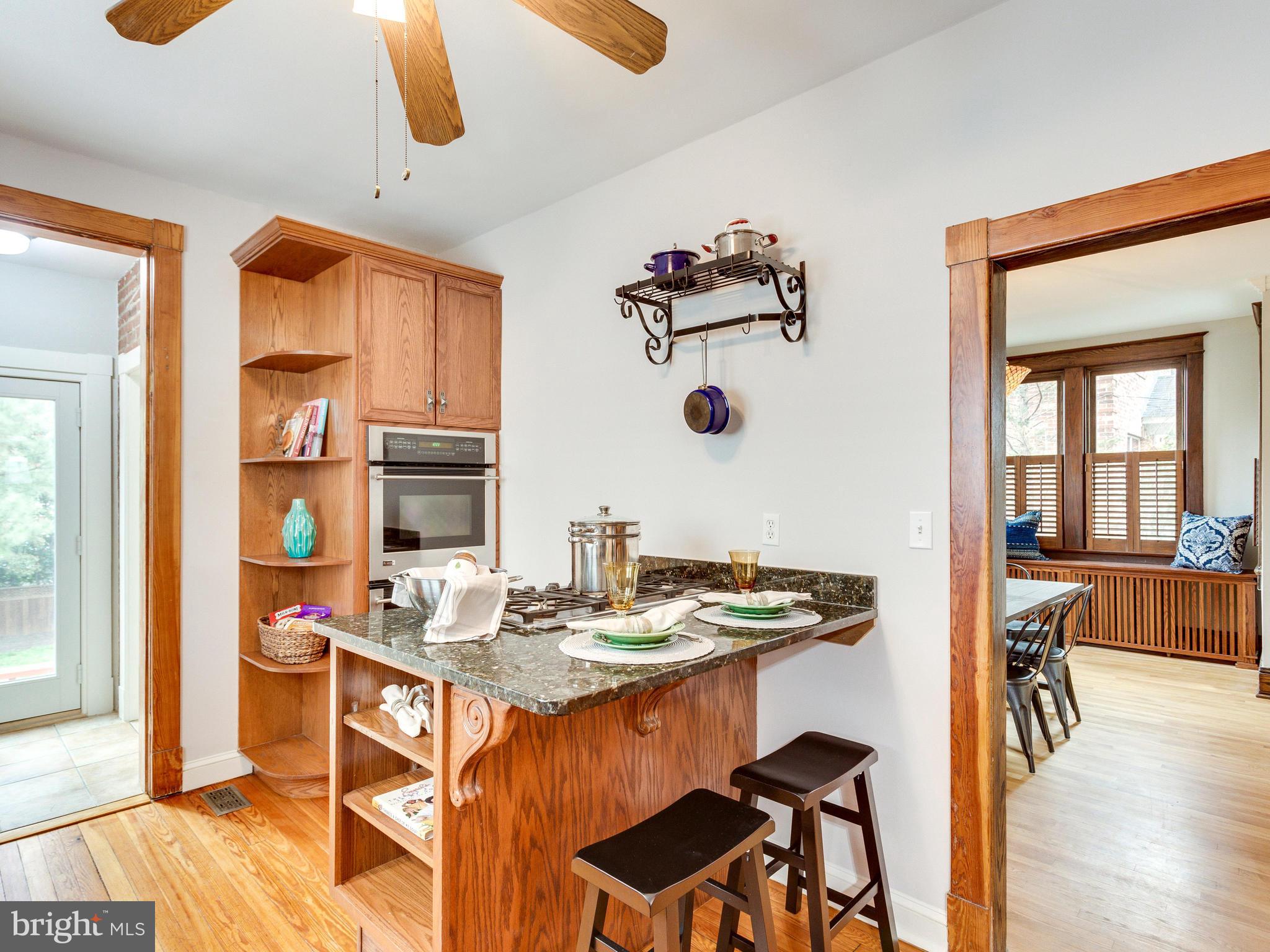 1107 Russell Road Alexandria, VA 22301 - Photo 11 of 29 a dining room with stainless steel appliances kitchen island granite countertop a dining table and chairs with wooden floor