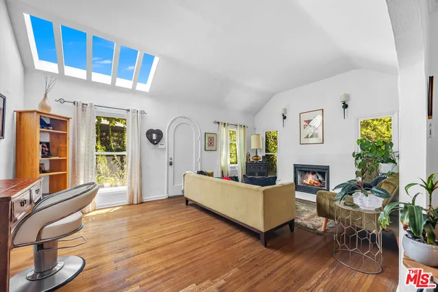 a living room with furniture fireplace and wooden floor