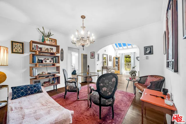 a living room with fireplace chandelier and a rug