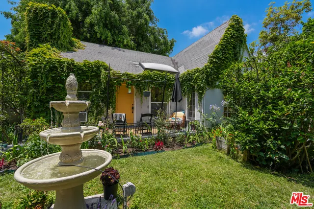 a view of a chair and table in backyard of the house