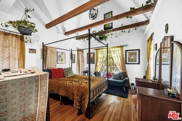 a bedroom with a bed and wooden floor