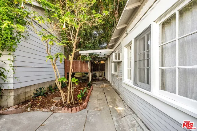 a view of a pathway with a chairs and table in a patio