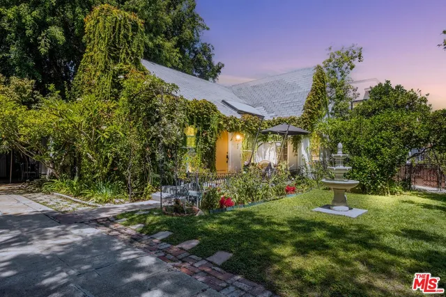 a front view of a house with a yard and a garden
