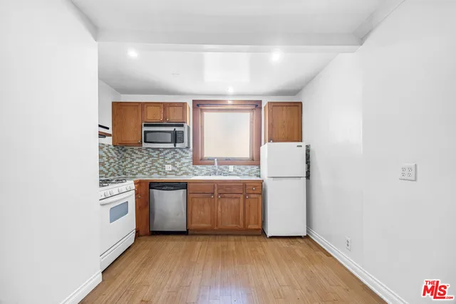 a kitchen with granite countertop white cabinets and white appliances